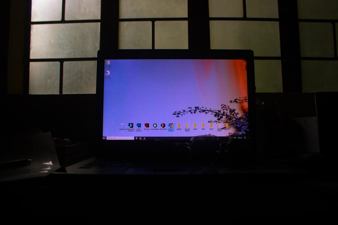 Computer monitor displaying colorful code in dark room